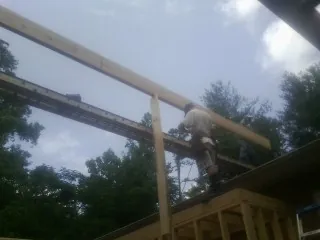 Carpenter setting a ridge beam over a new addition frame — Ice Dam Removal by Roofing Brothers in Oilville