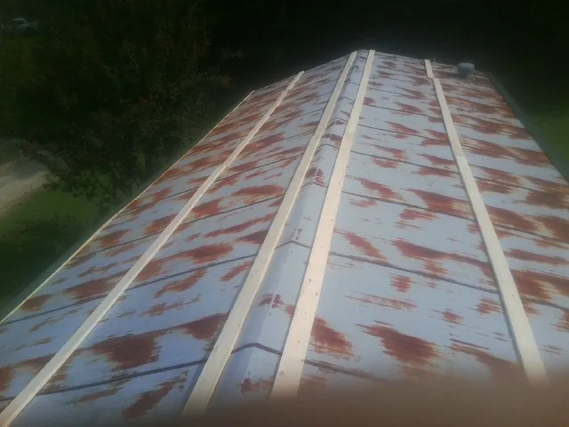 Rusted metal roof panels with new wood purlins before replacement — Storm Damage Roof Repair in Oilville by Roofing Brothers