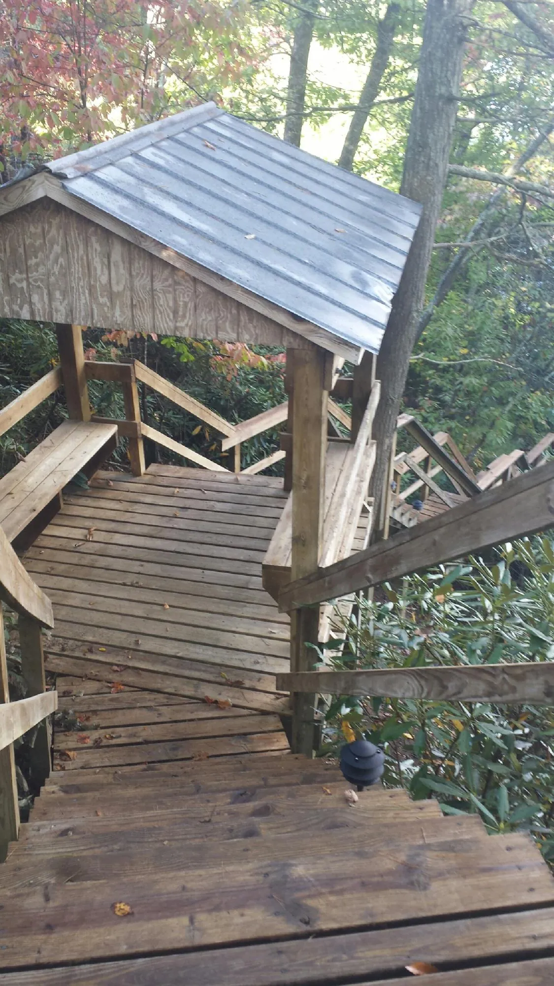 Metal roofed shelter over wooden steps on a wooded walkway — Skylight Repair & Installation work by our crew in Oilville