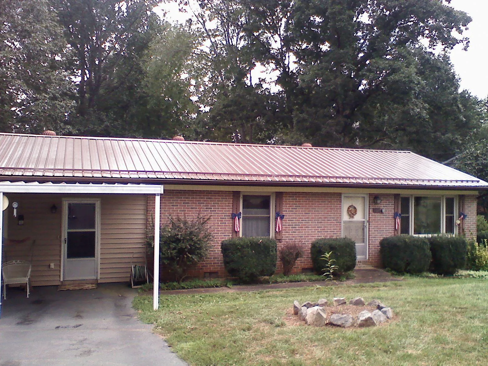 Bronze metal roof and carport on a brick ranch home — Roof Repair work by our crew in Oilville