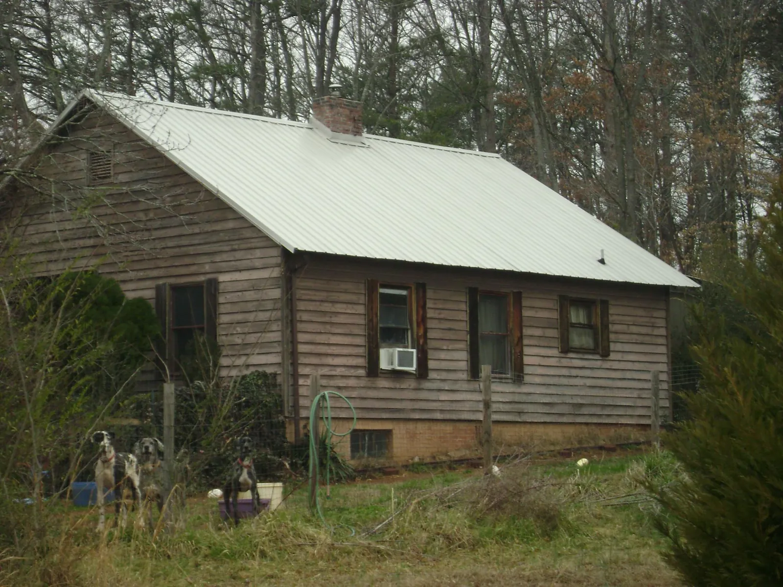 White metal roof on an old wood sided farmhouse, from a Metal Roof Installation job in Oilville