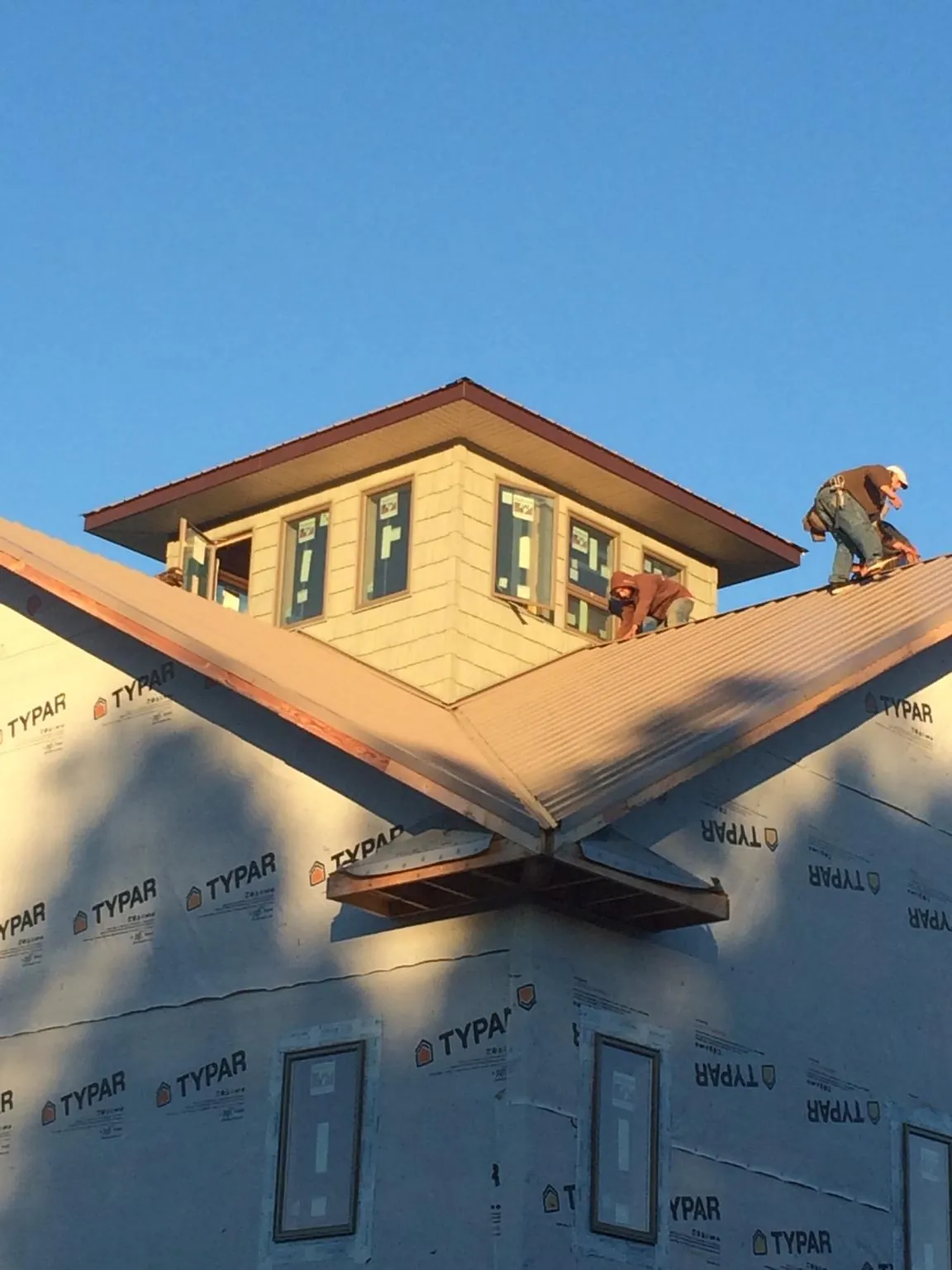 Roofers working around a rooftop cupola on a new metal roof at sunset — Roof Waterproofing in Oilville by Roofing Brothers